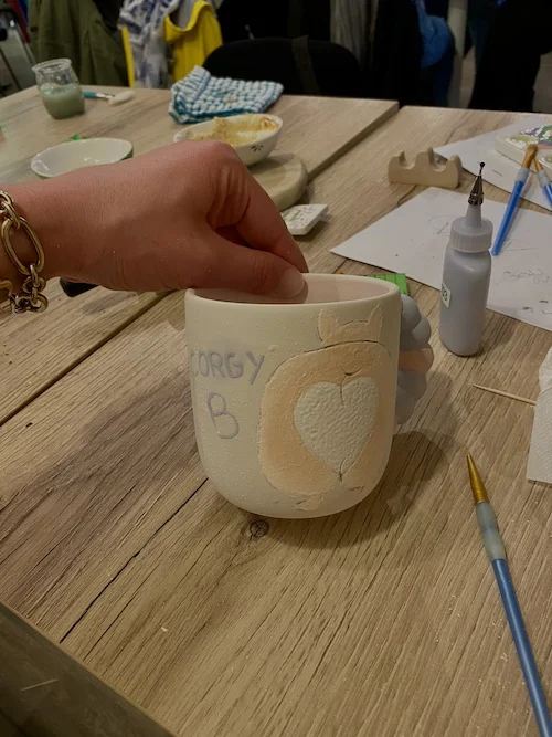 décoration d'une tasse lors d'un atelier dans un café céramique